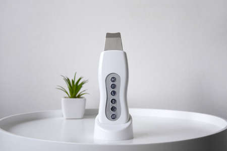 Ultrasonic scrubber for exfoliating skin and cleaning pores on a white table.の写真素材