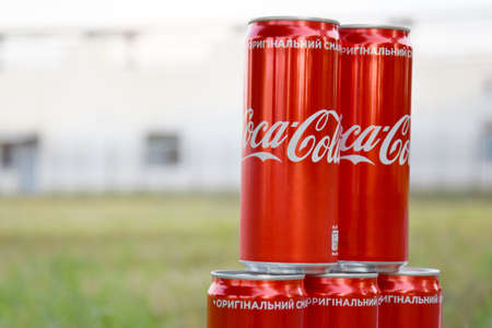Many cans of Coca-Cola soda with background blurring in a park.のeditorial素材