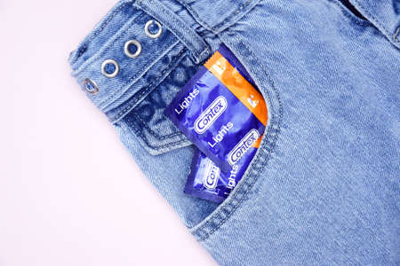 KHARKIV, UKRAINE - OCTOBER 16, 2021: Contex condom in jeans pocket. Contex is a brand of condoms and personal lubricants owned by Reckitt Benckiser. Sexual protection concept.のeditorial素材