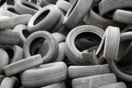 KHARKIV, UKRAINE - SEPTEMBER 4, 2021 :: A pile of used car tires for recycling. Lots of old wheel tires in a landfill.のeditorial素材
