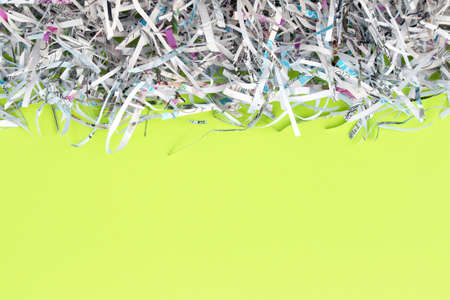 Shredded paper on light green background. Selective focus image.の写真素材