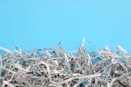 Shredded paper on light blue background. Selective focus image.の写真素材