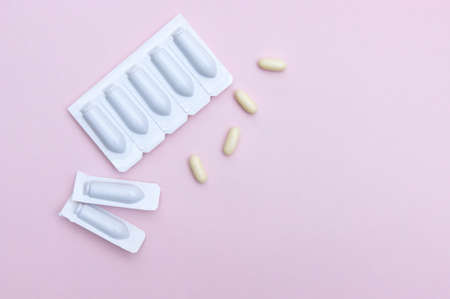 Gynecological medicines for women's health in form of suppository, capsules on pink background....