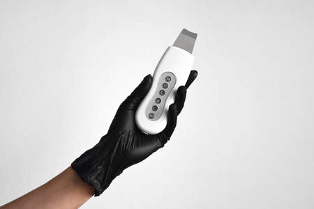 Ultrasonic skin exfoliating scrubber in female hand. On white background. beauty concept.の写真素材