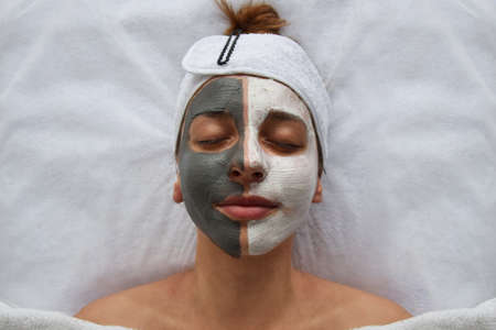 Face mask on a young girl, beautician's office. Beautician blog. Skin beauty and health concept.の写真素材