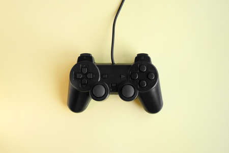 Joystick gaming controller on yellow background. minimalism. game concept.