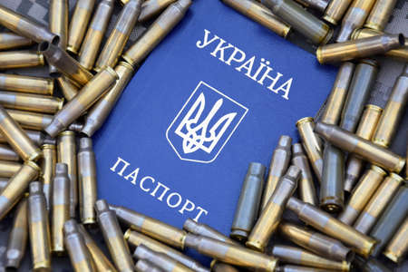 Ukrainian passport against the background of military camouflage, surrounded by shells. War in Ukraine. stop war.の写真素材