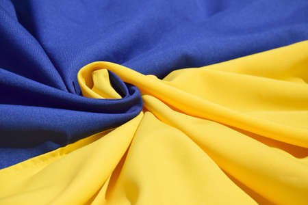 Fabric bent national flag of Ukraine, UA. Blue and yellow colors. close-up, background.の写真素材