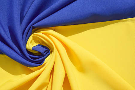 Fabric bent national flag of Ukraine, UA. Blue and yellow colors. close-up, background.の写真素材