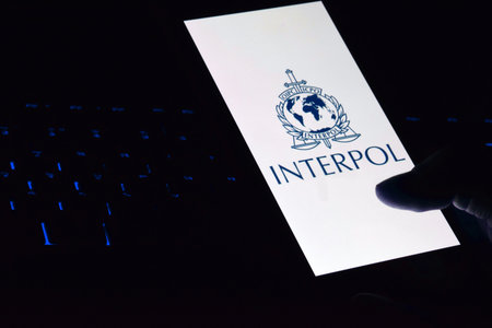 Kharkiv, Ukraine - June 16, 2022: Person holding smartphone with Interpol logo displayed on screen....