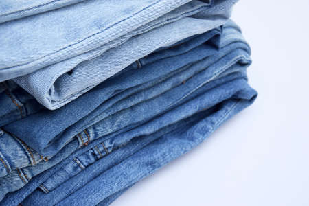 Lots of jeans pants in a stack. Denim background.の写真素材