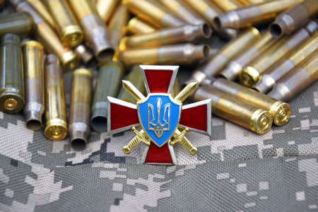Kharkiv, Ukraine - April 6, 2022: The badge of the ground forces of Ukraine against the background...
