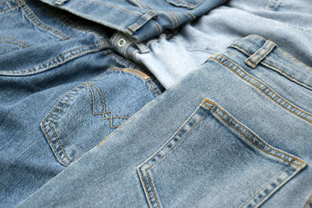 Lots of jeans pants in a stack. Denim background. The concept of buying, selling, shopping and...