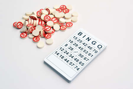 Many wooden chips with numbers and cards for a board game of bingo or lotto on a light background. Russian Lotto has similar rules to the classic worldwide bingo game.の写真素材
