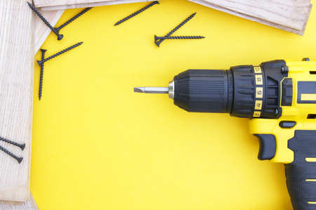 Yellow-black screwdriver on a yellow background, screws. copyspace.の写真素材