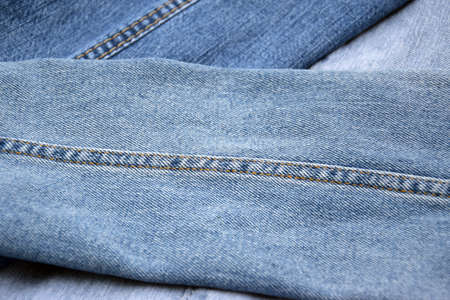 Lots of jeans pants in a stack. Denim background. The concept of buying, selling, shopping and...