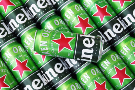 Many cans of Heineken alcoholic beer lie on a gray background.のeditorial素材