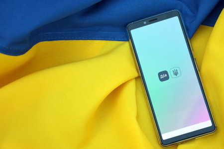 Kharkiv, Ukraine - October 18, 2022: Diia application on the smartphone screen against the background of the flag of Ukraine. Action is a mobile application with a web portal and a brand of e-government in Ukraine for citizens.のeditorial素材