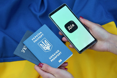 Kharkiv, Ukraine - October 18, 2022: Diia application on the smartphone screen against the background of the flag of Ukraine. Action is a mobile application with a web portal and a brand of e-government in Ukraine for citizens.のeditorial素材