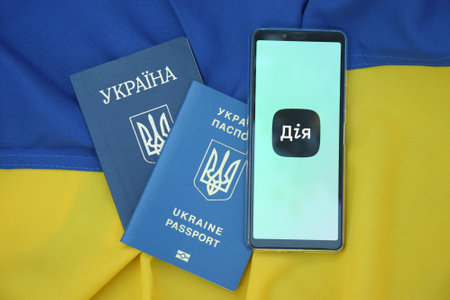 Diia application on the smartphone screen against the background of the flag of Ukraine.のeditorial素材