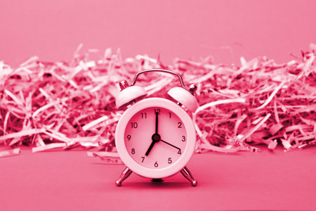 A white vintage clock in the foreground of 7:00 am on a light green background. Image toned in Viva Magenta, color of the 2023 yearの写真素材