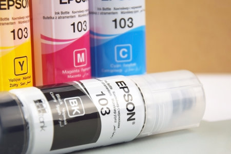 KHARKIV, UKRAINE - FEBRUARY 11, 2023: Four bottles of ink Epson, yellow, red, blue, black, built-in to the Epson L3150 series printer.のeditorial素材