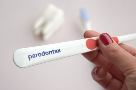 KHARKIV, UKRAINE - SEPTEMBER 30, 2022: Toothbrushes from Parodontax with a small figure of a tooth on a light background.のeditorial素材