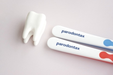 KHARKIV, UKRAINE - SEPTEMBER 30, 2022: Toothbrushes from Parodontax with a small figure of a tooth on a light background.のeditorial素材