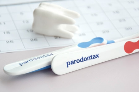 KHARKIV, UKRAINE - SEPTEMBER 30, 2022: Toothbrushes from Parodontax with a small figure of a tooth on a light background.のeditorial素材