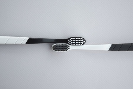 Toothbrushes with a small figure of a tooth on a light background. dental health concept.の写真素材