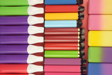 Set of multicolor disposable electronic cigarettes on a red background. The concept of modern smoking, vaping and nicotine.の写真素材