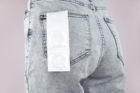 Condoms in jeans pocket. prevent infections. World AIDS Day. The concept of sexual health.の写真素材