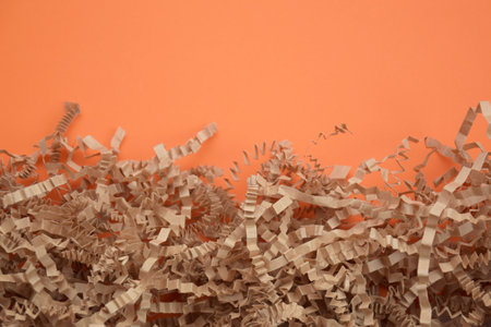 Shredded paper on light orange background. selective focus image.の写真素材
