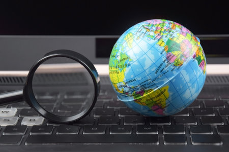 Laptop keyboard with world globe on top. The concept of searching for information data on the...