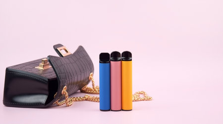 Set of multicolor disposable electronic cigarettes on a pink background. The concept of modern smoking, vaping and nicotine.の写真素材