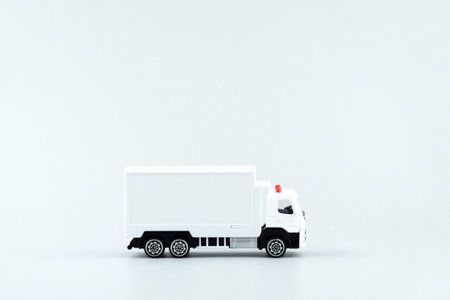 White toy truck with boxes on a light background, space for text.の写真素材