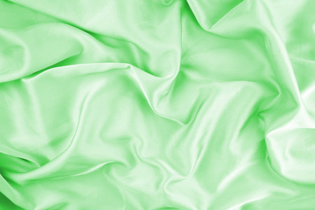 Green chiffon fabric texture for background. Silk fabric. Selective focus.