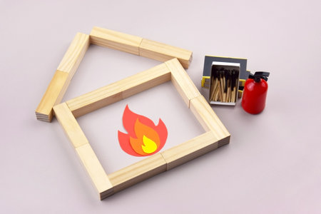 A box of matches placed next to a toy red fire extinguisher against a light background. Fire safety concept. International Firefighter's Day.の写真素材