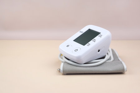 Digital blood pressure tonometer and pack of pills on a light background with copy space. Healthcare...