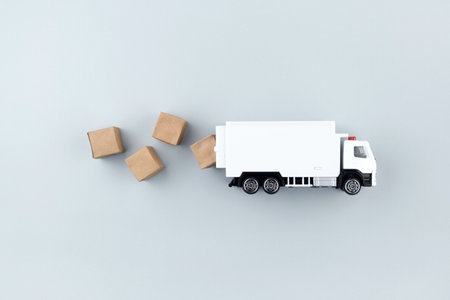 White toy truck with boxes on a light background, space for text.の写真素材