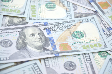 A pile of one hundred US banknotes with president portraits. Cash of hundred dollar bills, dollar...