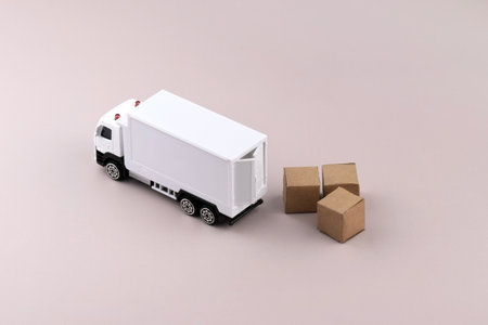 White toy truck with boxes on a light background, space for text. Logistics and wholesale trade concept.の写真素材