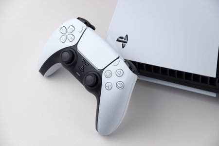 Kharkiv, Ukraine - July 10, 2025: The white Sony PlayStation 5 and controller on the white table.