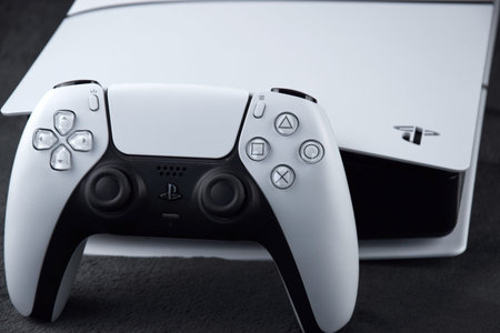 Kharkiv, Ukraine - July 10, 2025: The white Sony PlayStation 5 and controller on the dark table.