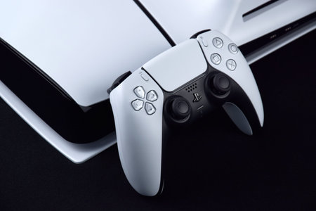 Kharkiv, Ukraine - July 10, 2025: The white Sony PlayStation 5 and controller on the dark table.