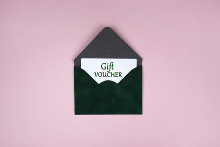 Gift voucher in a green envelope on a light background