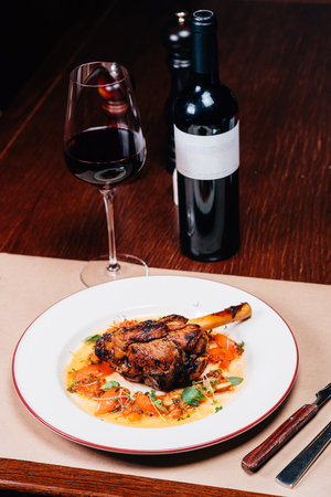 dinner on the table, meat, a glass of red wine, a bottleの写真素材