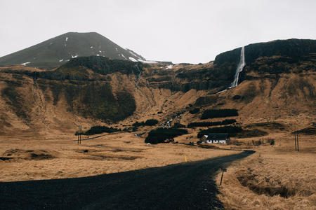 Bjarnafoss is a tall waterfall tumbling right behind the small farming hamlet of Buirの写真素材