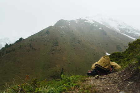 A man in the mountains lying photographingの写真素材