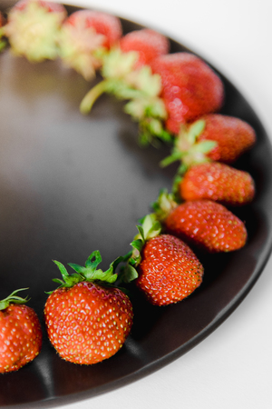 fresh strawberries in a plate on a white backgroundの写真素材
